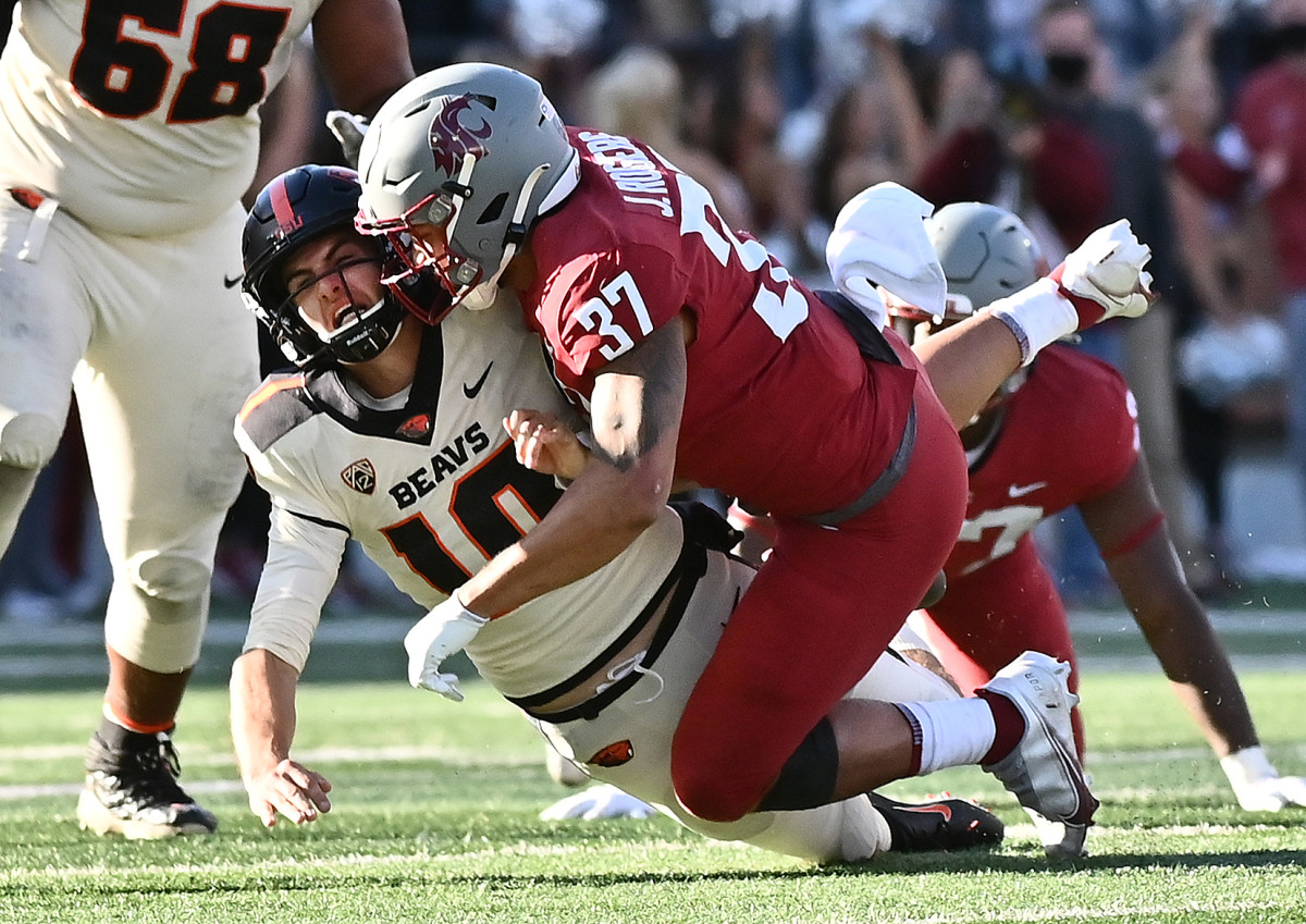 Oregon State Beavers quarterback Chance Nolan (10) is hit after the throw by Washington State Cougars linebacker Justus Rogers (37).