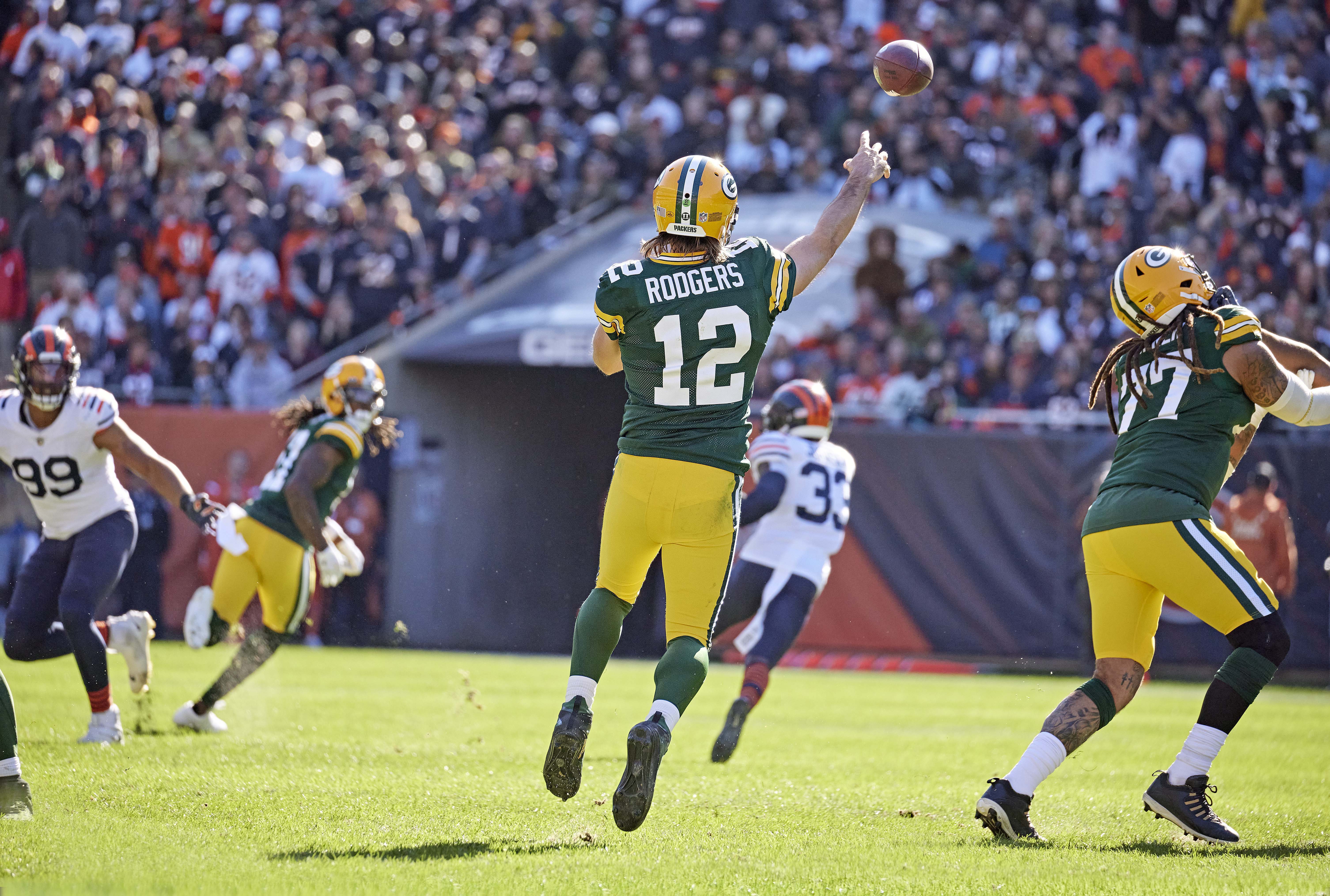 Aaron Rodgers throws downfield while both feet are off the ground during a game against the Bears