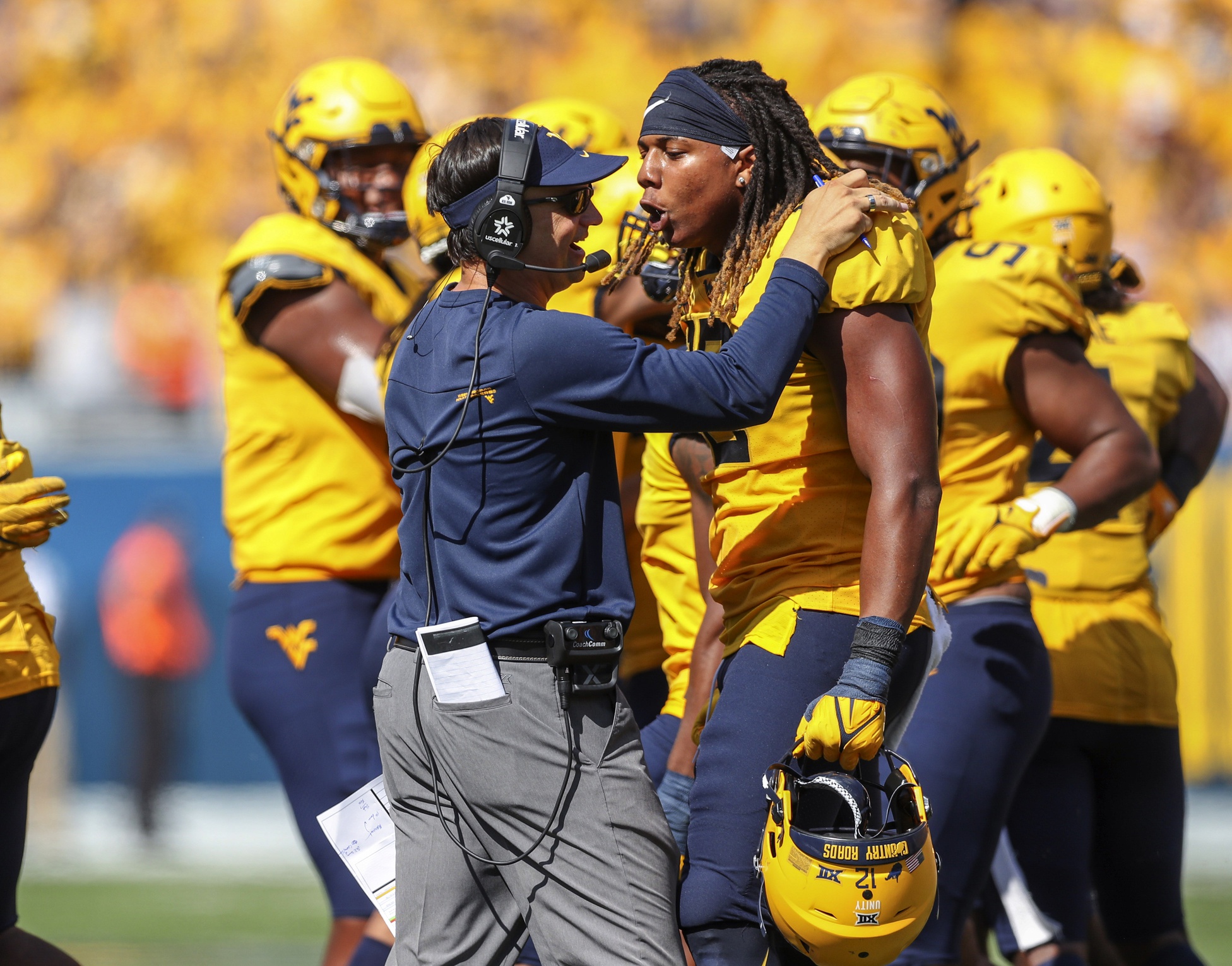 Sep 18, 2021; Morgantown, West Virginia, USA; West Virginia Mountaineers head coach Neal Brown celebrates with defensive lineman Taijh Alston (12) following a turnover during the fourth quarter against the Virginia Tech Hokies at Mountaineer Field at Milan Puskar Stadium.