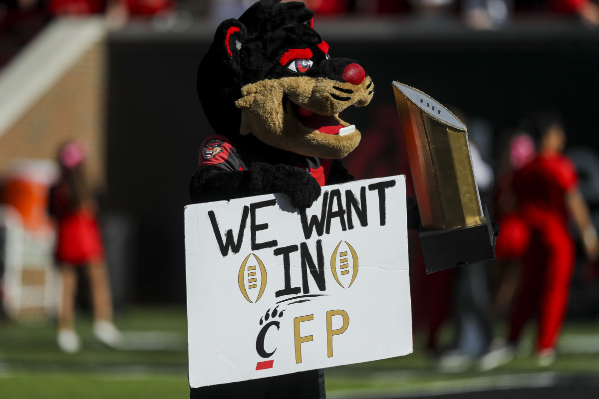 Oct 16, 2021; Cincinnati, Ohio, USA; The Cincinnati Bearcats mascot poses with a sign and a replica of the College Football Playoff National Championship trophy at the end of the game against the UCF Knights at Nippert Stadium. Mandatory Credit: Katie Stratman-USA TODAY Sports