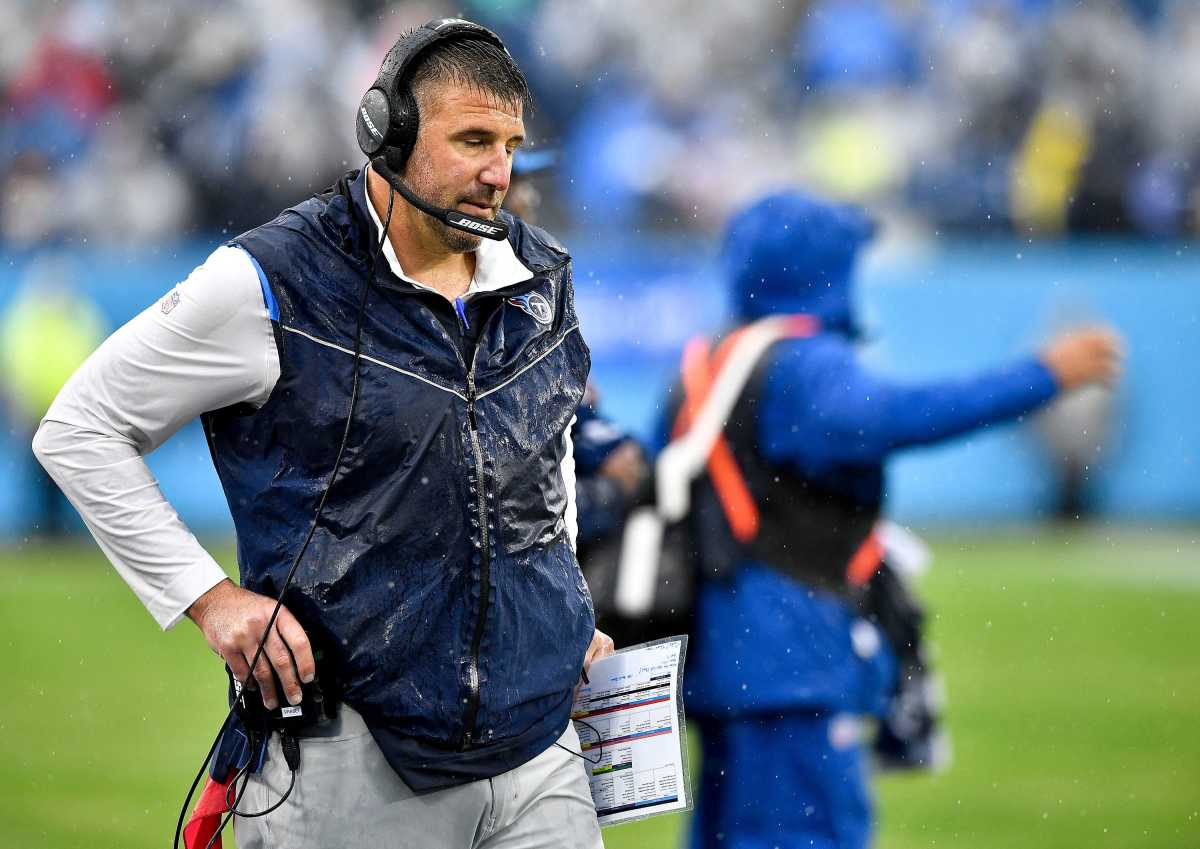 Mike Vrabel looks away from the field while getting soaked with rain during the Titans' loss to the Texans