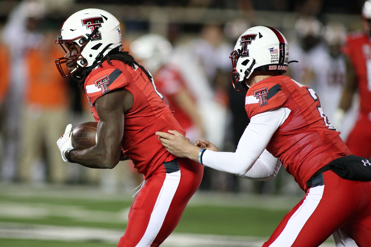Nov 20, 2021; Lubbock, Texas, USA; Texas Tech Red Raiders quarterback Behren Morton (2) hands the ball in the second half to running back SaRodorick Thompson (4) against the Oklahoma State Cowboys in the game at Jones AT&T Stadium. Mandatory Credit: Michael C. Johnson-USA TODAY Sports