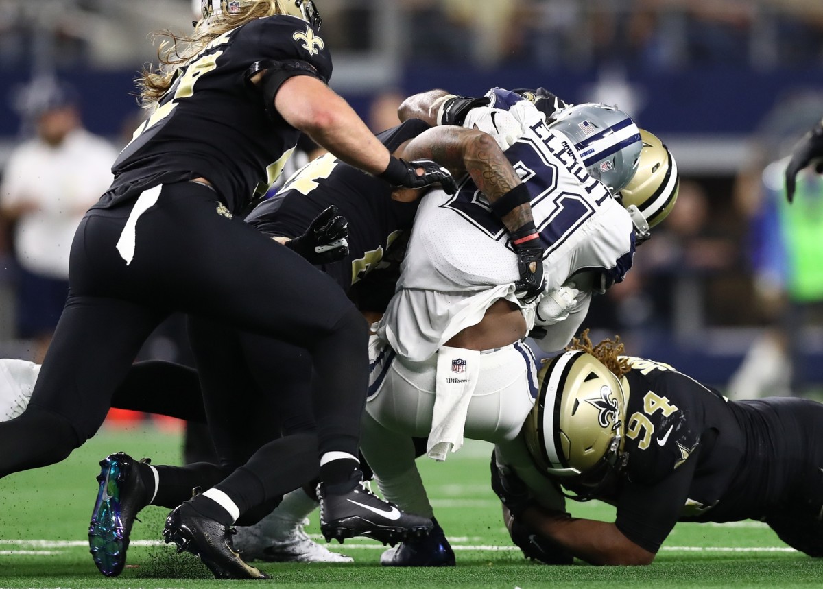 Dallas Cowboys running back Ezekiel Elliott (21) is tackled after short gain by the New Orleans Saints. Mandatory Credit: Matthew Emmons-USA TODAY Sports