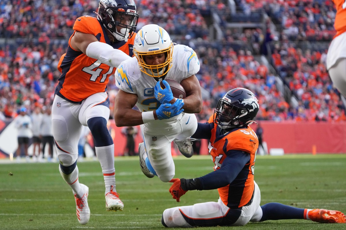 Los Angeles Chargers running back Austin Ekeler (30) dives into the end zone past Denver Broncos inside linebacker Kenny Young (41) and inside linebacker Baron Browning (56) in the second quarter at Empower Field at Mile High.