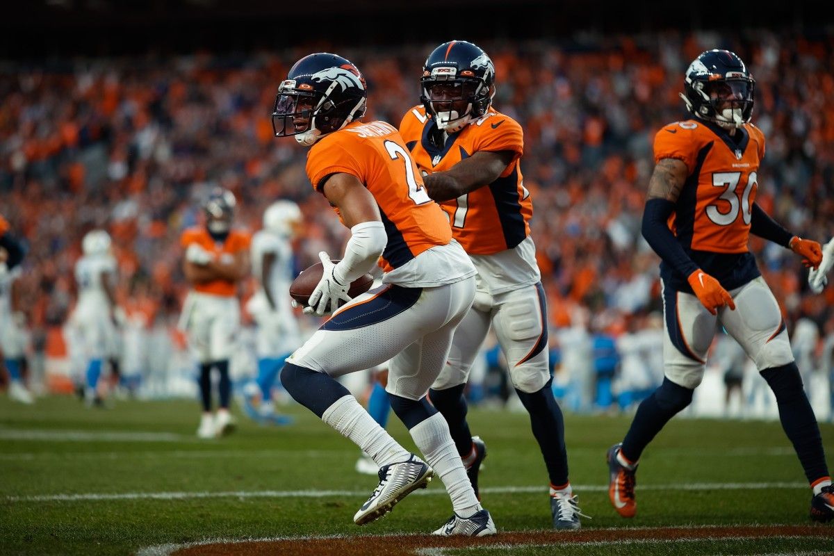 Denver Broncos cornerback Pat Surtain II (2) reacts with cornerback Nate Hairston (27) after intercepting a ball in the fourth quarter against the Los Angeles Chargers at Empower Field at Mile High.