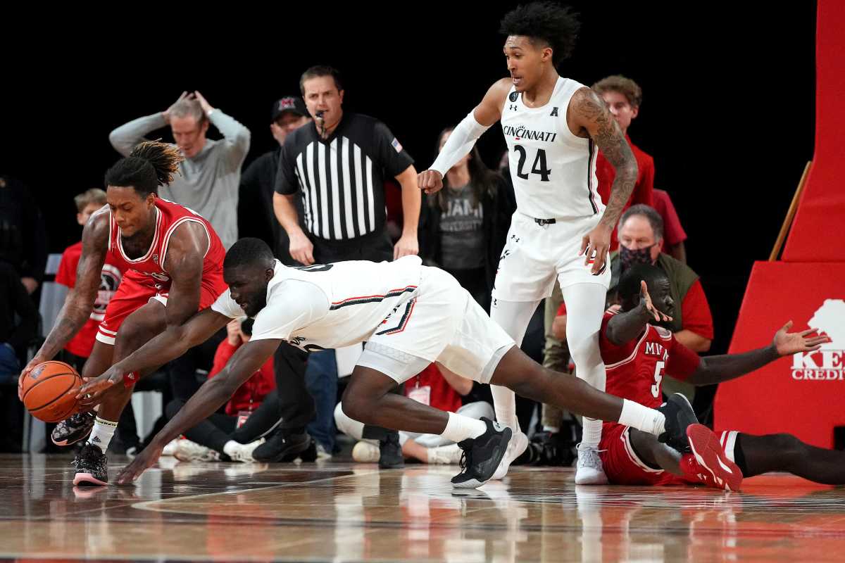 Miami (Oh) Redhawks forward Dalonte Brown (13) and Cincinnati Bearcats forward Abdul Ado (00) compete for a loose ball in the second half of an NCAA men's college basketball game, Wednesday, Dec. 1, 2021, at Millett Hall in Oxford, Ohio. The Cincinnati Bearcats won, 59-58. Cincinnati Bearcats At Miami Oh Redhawks Dec 1