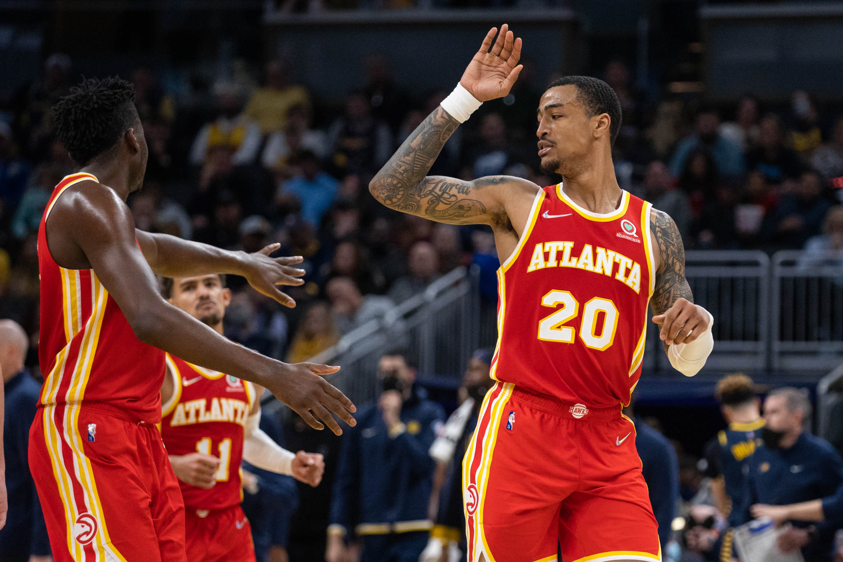 Atlanta Hawks forward John Collins (20) celebrates with center Clint Capela (15) during a timeout in the second half against the Indiana Pacers at Gainbridge Fieldhouse.