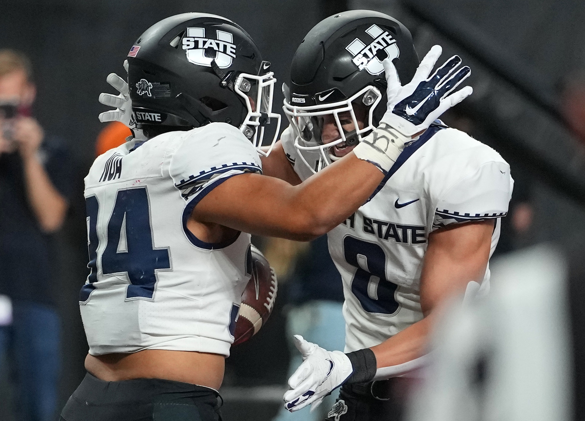 Oct 16, 2021; Paradise, Nevada, USA; Utah State Aggies running back Elelyon Noa (34) celebrates with Utah State Aggies wide receiver Derek Wright (8) after scoring the game-winning touchdown against the UNLV Rebels at Allegiant Stadium. Mandatory Credit: Stephen R. Sylvanie-USA TODAY Sports