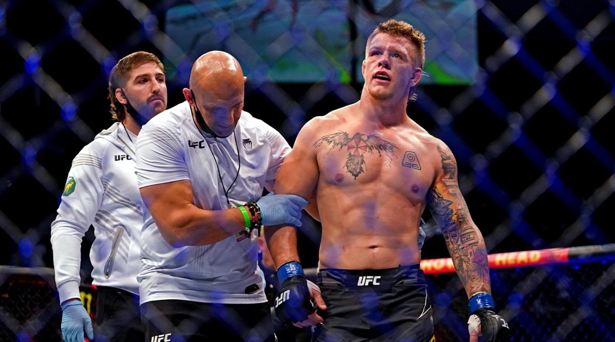 Apr 24, 2021; Jacksonville, Florida, USA; Jimmy Crute (Blue Gloves) reacts after beating defeated by Anthony Smith (Red Gloves) due for a leg injury during UFC 261 at VyStar Veterans Memorial Arena.