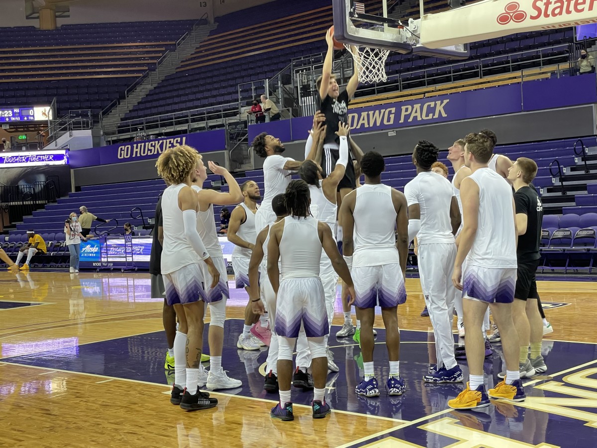 A pre-game UW ritual is letting a manager dunk, with help.