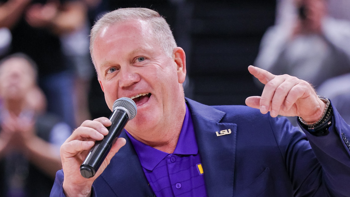 Brian Kelly speaks to LSU fans at a basketball game.
