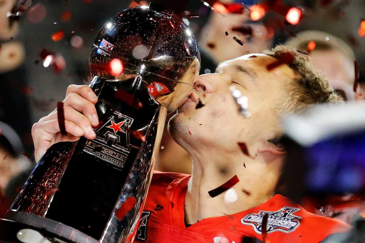 Cincinnati Bearcats quarterback Desmond Ridder (9) kisses the American Athletic Conference Championship trophy during a ceremony after the American Athletic Conference Championship football game between the Cincinnati Bearcats and the Houston Cougars at Nippert Stadium in Cincinnati on Saturday, Dec. 4, 2021. The Bearcats remained unbeaten as they won the AAC Championship with a 35-20. Houston Cougars At Cincinnati Bearcats American Athletic Conference Championship