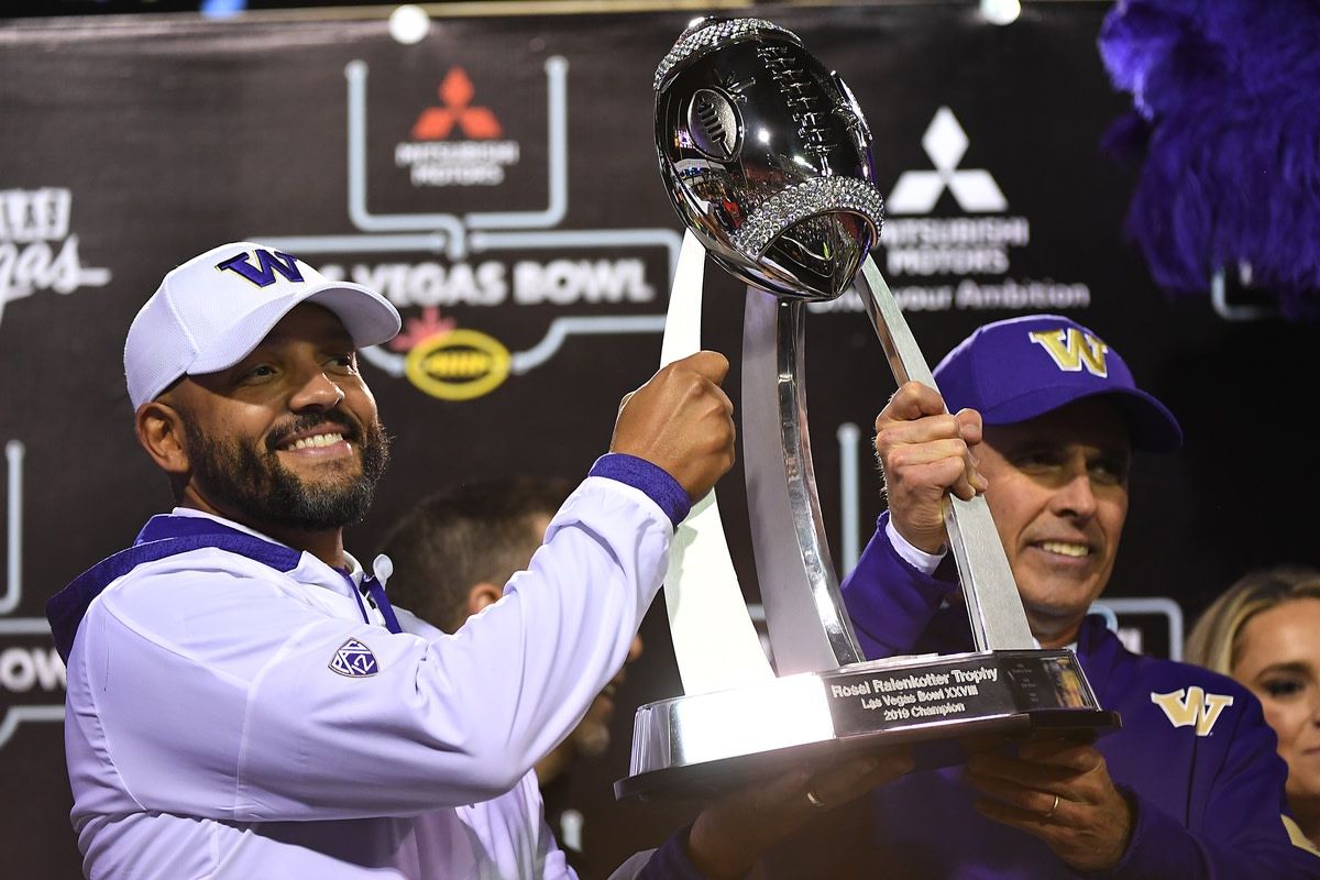 Jimmy Laken and Chris Petersen raise the Las Vegas Bowl trophy in 2019.
