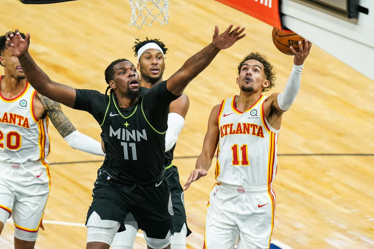 Atlanta Hawks guard Trae Young (11) a layup while Minnesota Timberwolves center Naz Reid (11) defends during the first quarter at Target Center.