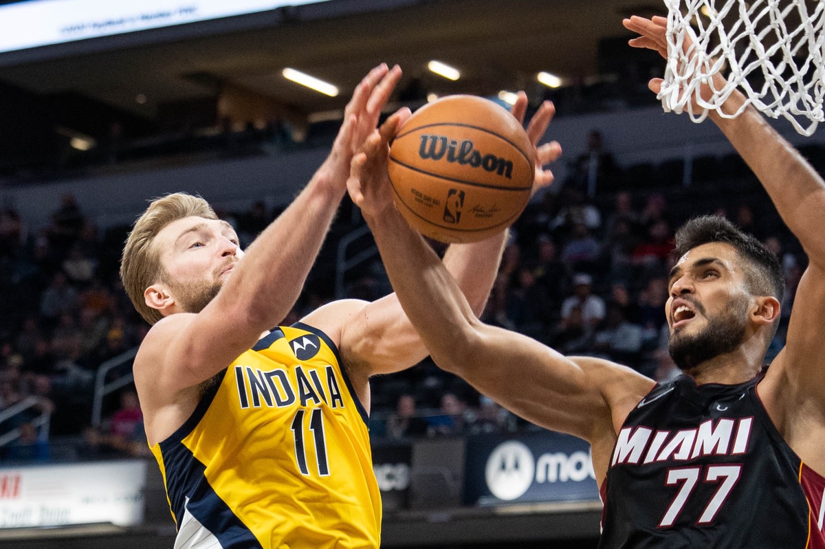 Dec 3, 2021; Indianapolis, Indiana, USA; Indiana Pacers forward Domantas Sabonis (11) and Miami Heat center Omer Yurtseven (77) fight for a rebound in the second half at Gainbridge Fieldhouse. Mandatory Credit: Trevor Ruszkowski-USA TODAY Sports