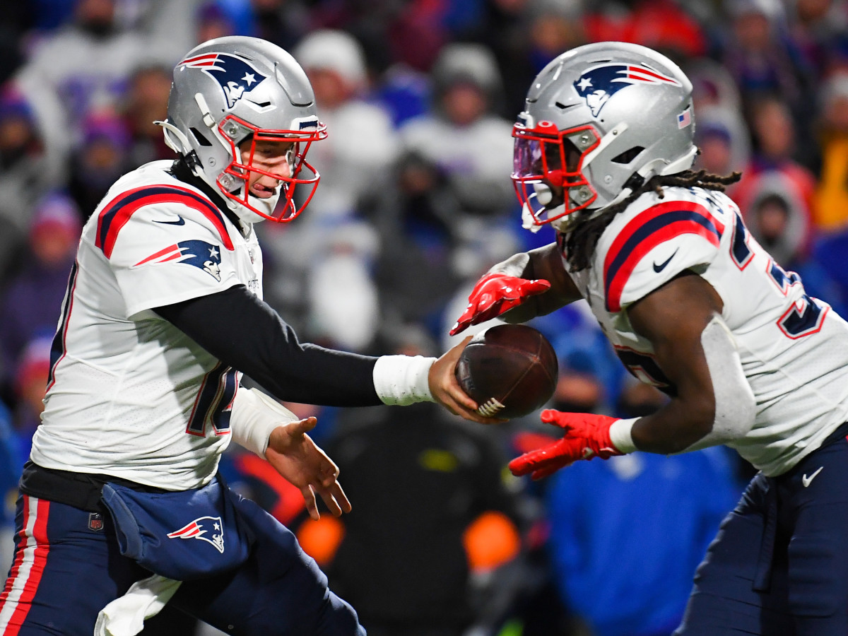 New England Patriots quarterback Mac Jones (left) hands the ball off to running back Rhamondre Stevenson (right) against the Buffalo Bills during the second half at Highmark Stadium.