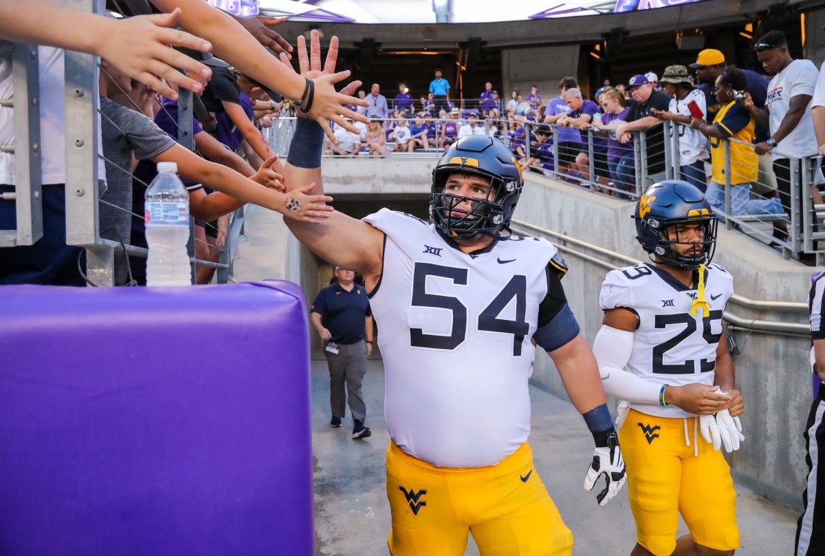 Oct 23, 2021; Fort Worth, Texas, USA; West Virginia Mountaineers offensive lineman Zach Frazier (54) gives a high five to fans prior to their game against the TCU Horned Frogs at Amon G. Carter Stadium.