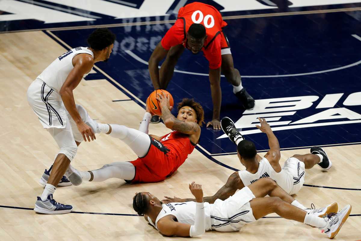 Cincinnati Bearcats guard Jeremiah Davenport (24) looks for a pass as he dives on a loose ball in the first half of the 89th Annual Crosstown Shootout basketball game between the Xavier Musketeers and the Cincinnati Bearcats at the Cintas Center in Cincinnati on Saturday, Dec. 11, 2021. Xavier led 42-27 at halftime. 2021 Crosstown Shootout