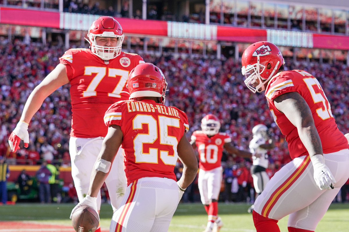 Dec 12, 2021; Kansas City, Missouri, USA; Kansas City Chiefs running back Clyde Edwards-Helaire (25) celebrates with guard Andrew Wylie (77) and offensive tackle Orlando Brown (57) after scoring against the Las Vegas Raiders during the first half at GEHA Field at Arrowhead Stadium. Mandatory Credit: Denny Medley-USA TODAY Sports