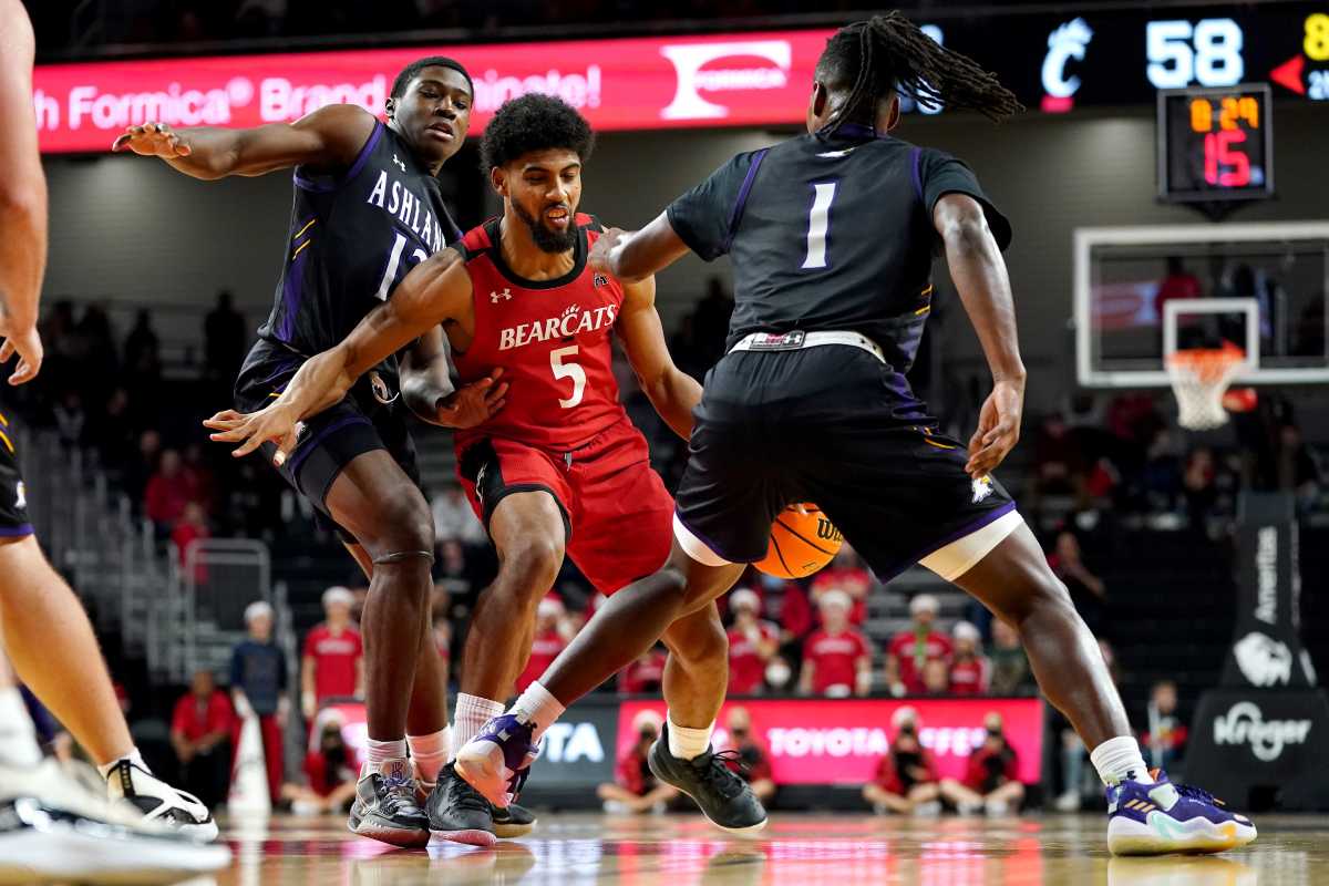 Cincinnati Bearcats guard David DeJulius (5) protects possession as Ashland Eagles guard Dylan Fasoyiro (12) defends in the second half of an NCAA college basketball game, Saturday, Dec. 18, 2021, at Fifth Third Arena in Cincinnati. Ashland Eagles At Cincinnati Bearcats Dec 18