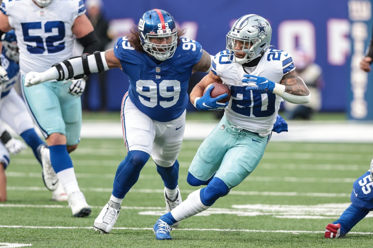 Dec 19, 2021; East Rutherford, New Jersey, USA; Dallas Cowboys running back Tony Pollard (20) carries the ball as New York Giants defensive end Leonard Williams (99) pursues during the second half at MetLife Stadium.