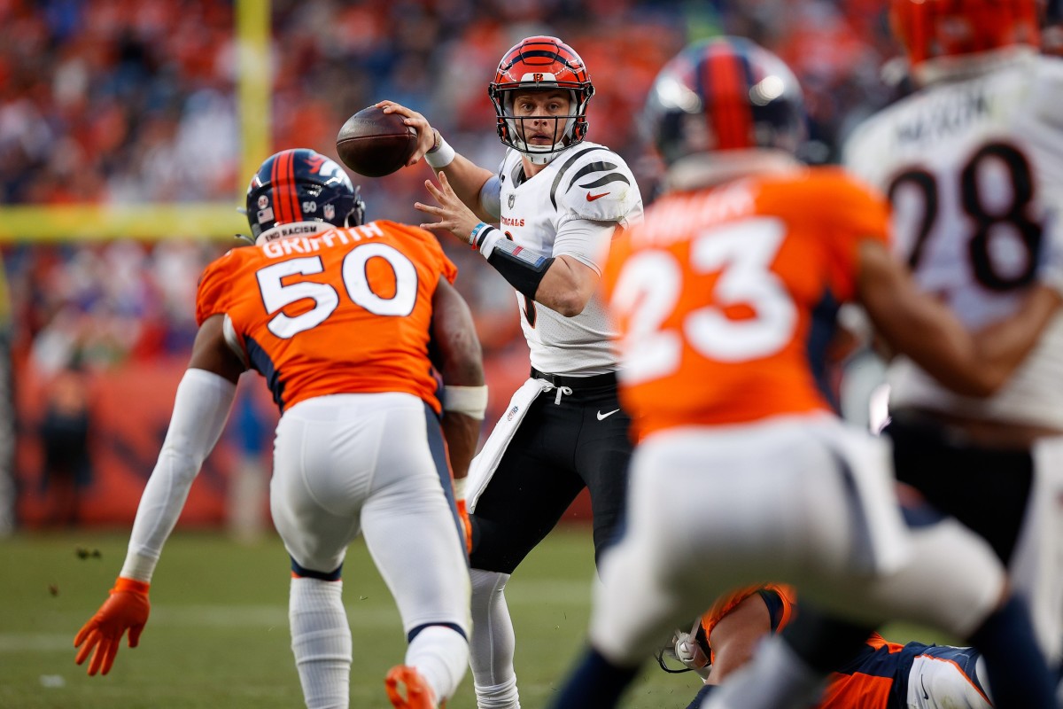 Cincinnati Bengals quarterback Joe Burrow (9) passes under pressure from Denver Broncos linebacker Jonas Griffith (50) in the third quarter at Empower Field at Mile High.