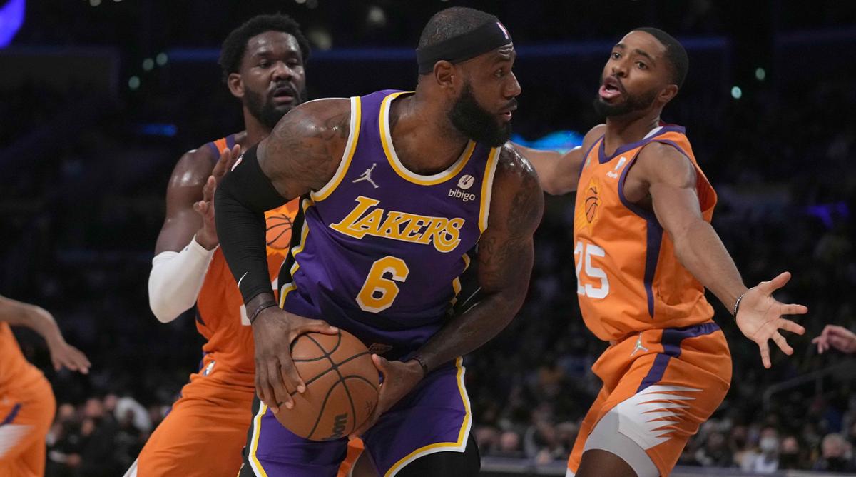 Oct 22, 2021; Los Angeles, California, USA; Los Angeles Lakers forward LeBron James (6) is defended by Phoenix Suns forward Mikal Bridges (25) and center Deandre Ayton (22) in the first half at Staples Center.