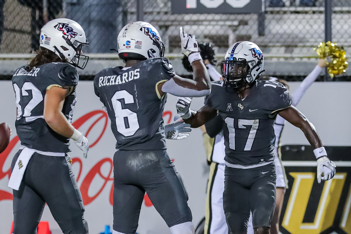 Nov 20, 2021; Orlando, Florida, USA; UCF Knights wide receiver Amari Johnson (17) celebrates his touchdown with running back Mark-Antony Richards (6) and tight end Alec Holler (82) against the Connecticut Huskies during the second half at Bounce House.