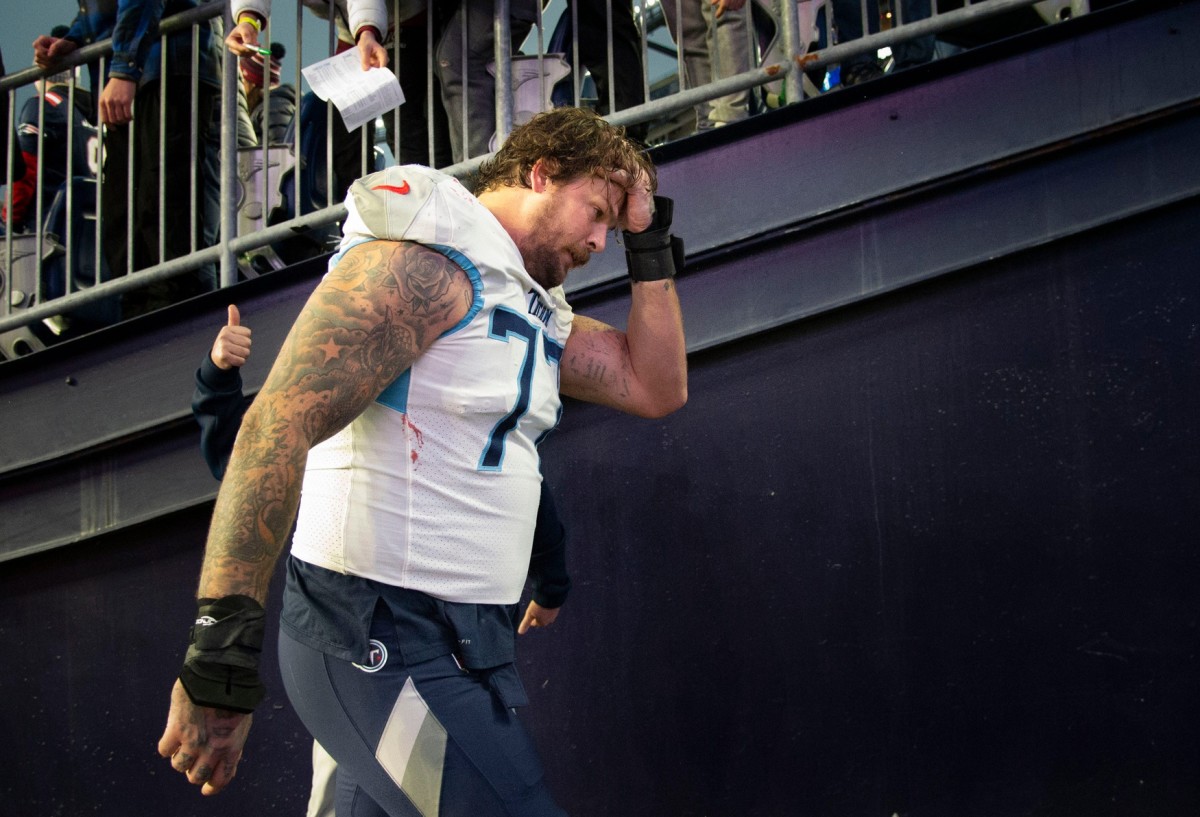 Tennessee Titans offensive tackle Taylor Lewan (77) holds his head as he walks off the field after their 36 to 13 loss against the New England Patriots at Gillette Stadium Sunday, Nov. 28, 2021 in Foxborough, Mass.