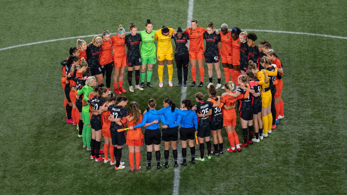 NWSL players from Portland and Houston huddle together