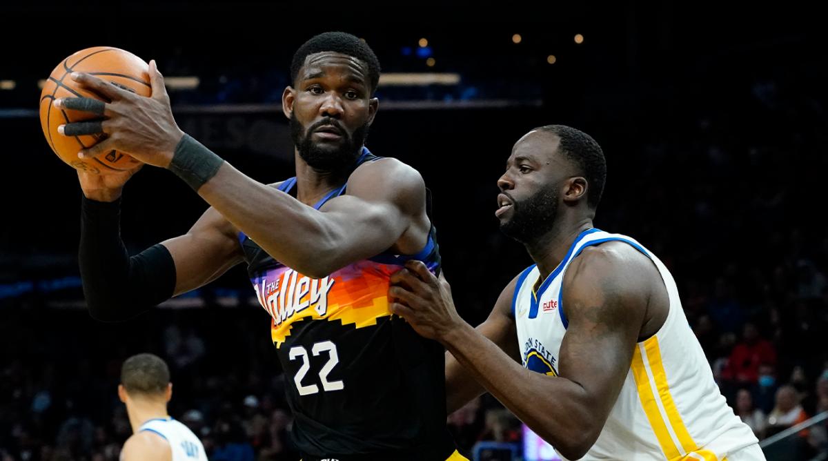 Phoenix Suns center Deandre Ayton (22) backs down Golden State Warriors forward Draymond Green during the second half of an NBA basketball game, Tuesday, Nov. 30, 2021, in Phoenix.