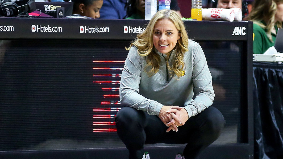 Baylor coach Nicki Collen smiles while crouching on the sideline