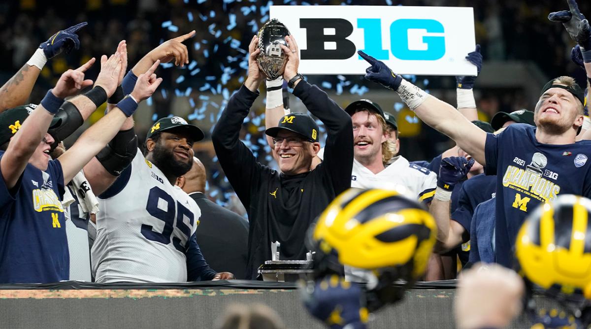 Michigan head coach Jim Harbaugh celebrates with his team after the Big Ten championship NCAA college football game against Iowa, Saturday, Dec. 4, 2021, in Indianapolis. Michigan won 42-3.