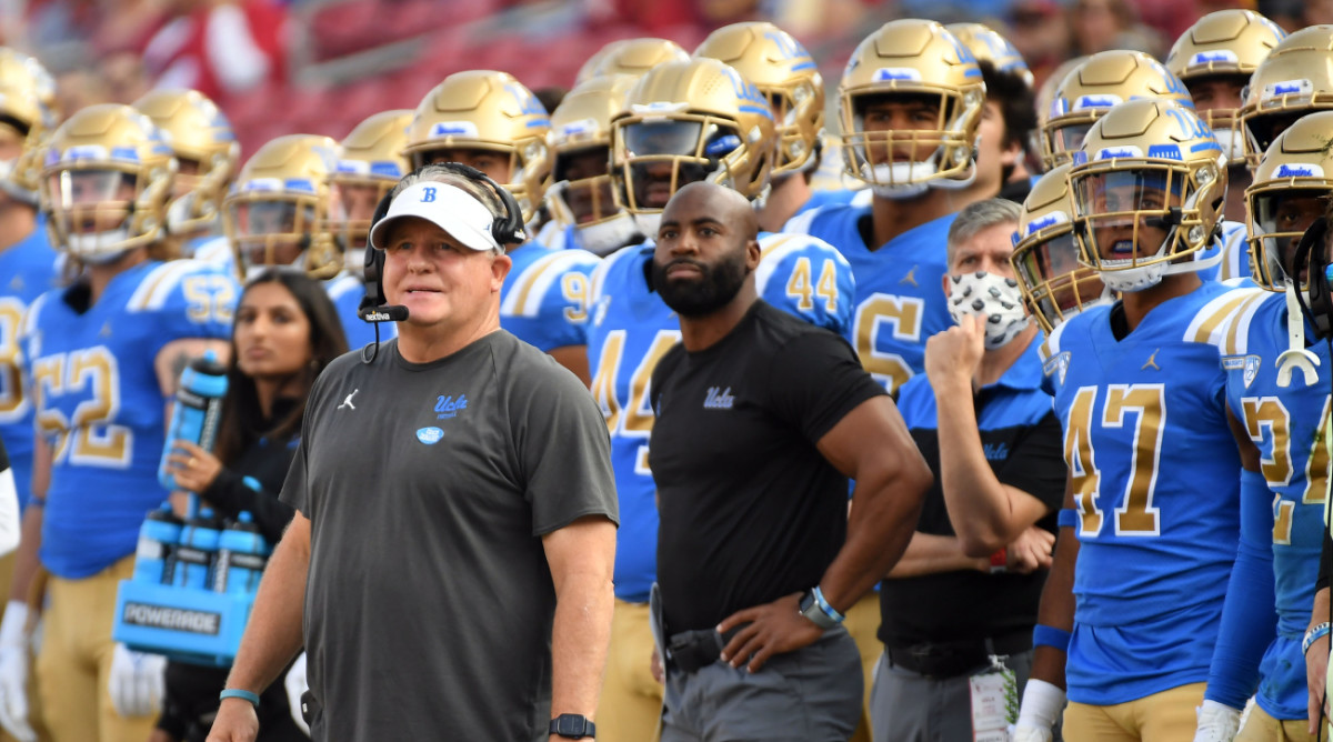 Chip Kelly and UCLA football players on the sideline.