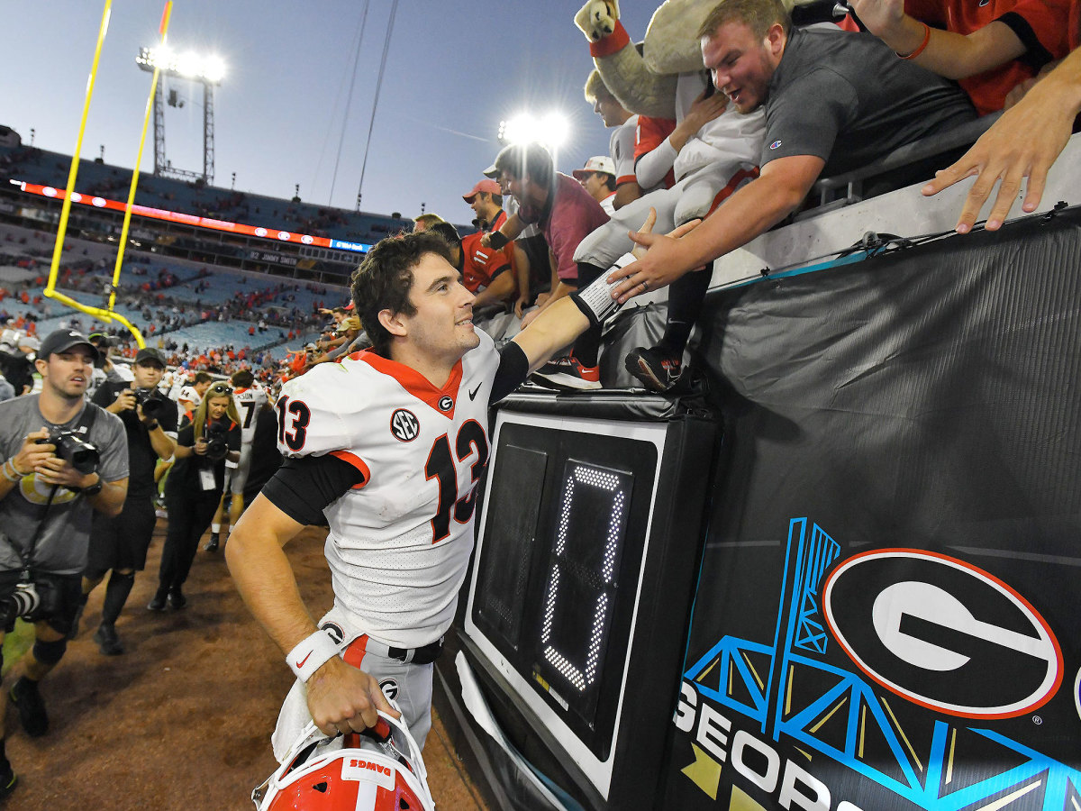 Georgia QB Stetson Bennett slaps hands with fans after a game