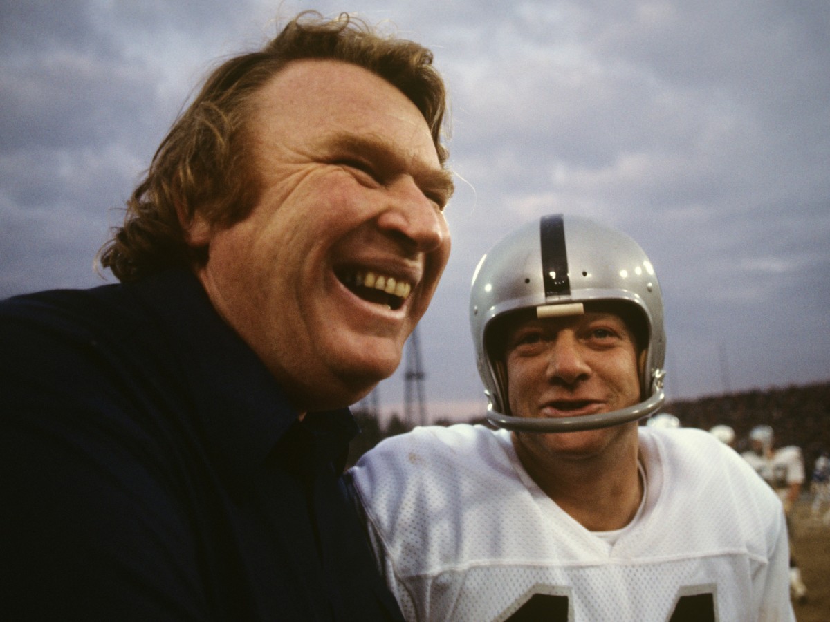 Oakland Raiders head coach John Madden and Errol Mann (14) on field after game vs Baltimore Colts