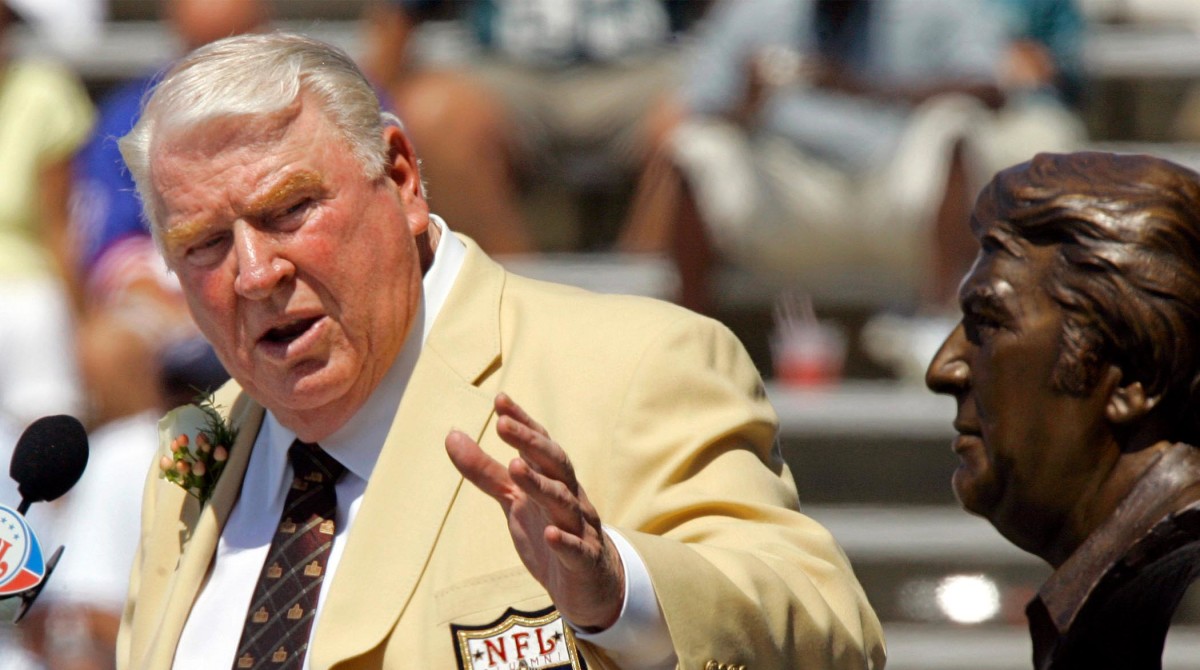 FILE - Former Oakland Raiders coach John Madden gestures toward a bust of himself during his enshrinement into the Pro Football Hall of Fame in Canton, Ohio, Aug. 5, 2006.