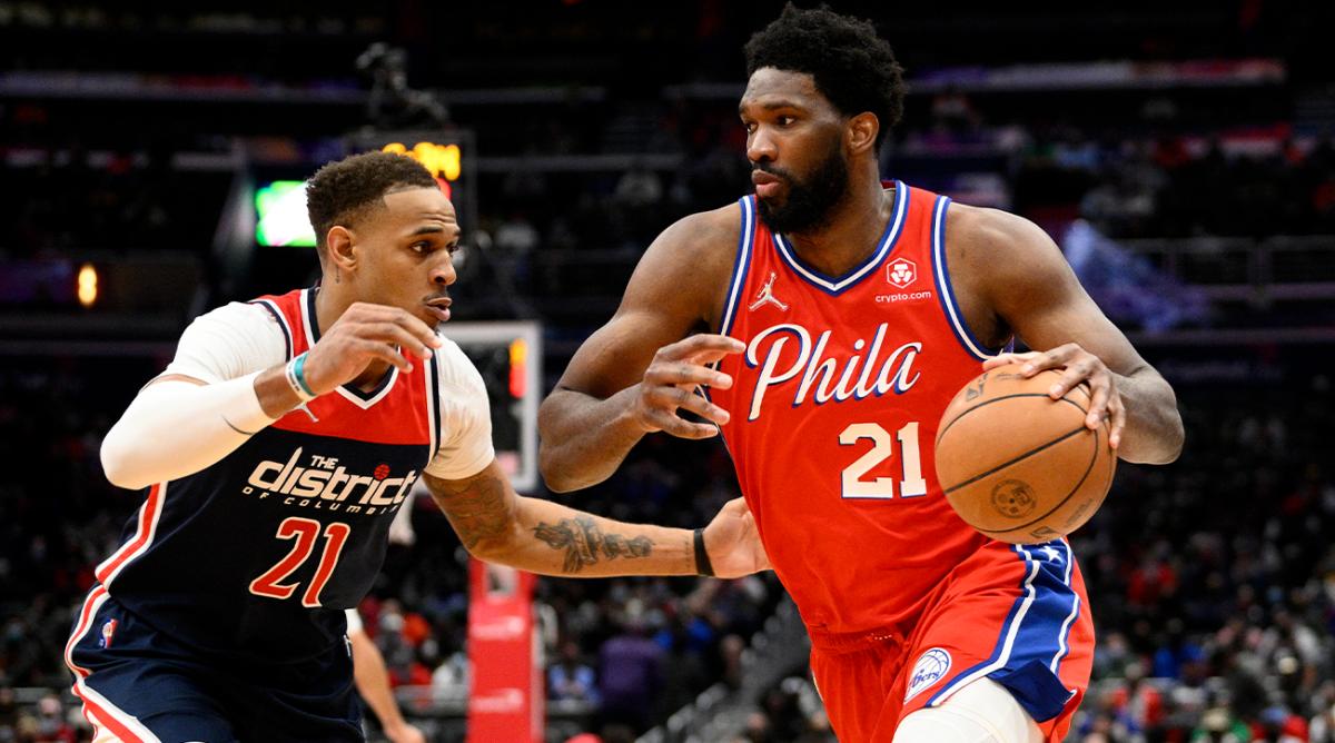 Philadelphia 76ers center Joel Embiid, right, drives to the basket against Washington Wizards center Daniel Gafford, left, during the second half of an NBA basketball game, Sunday, Dec. 26, 2021, in Washington. The 76ers won 117-96.