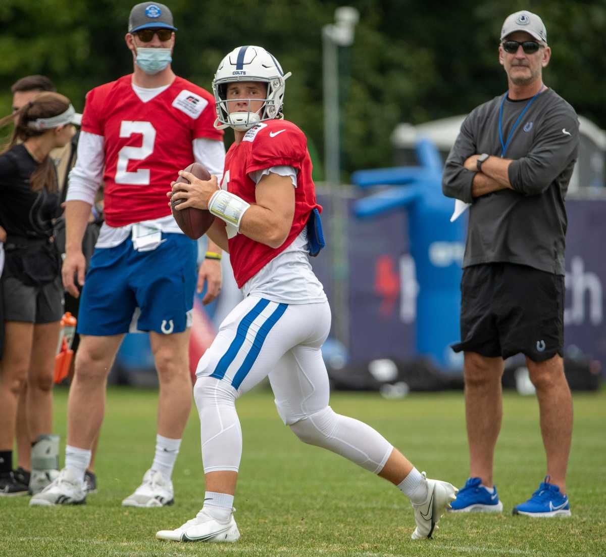 Indianapolis Colts quarterback Sam Ehlinger (4) drops back to pass as he is watched by Carson Wentz and Indianapolis Colts head coach Frank Reich during a combined Indianapolis Colts and Carolina Panthers practice at Grand Park in Westfield on Thursday, August 12, 2021, during Colts camp. Colts Entertain Panthers