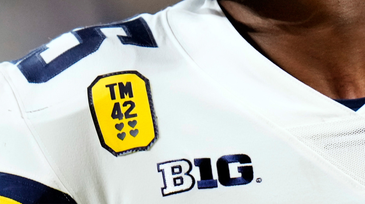 Michigan running back Hassan Haskins wears a patch honoring the Oxford High School shooting victims while warming up for the Big Ten championship NCAA college football game against Iowa, Saturday, Dec. 4, 2021, in Indianapolis.