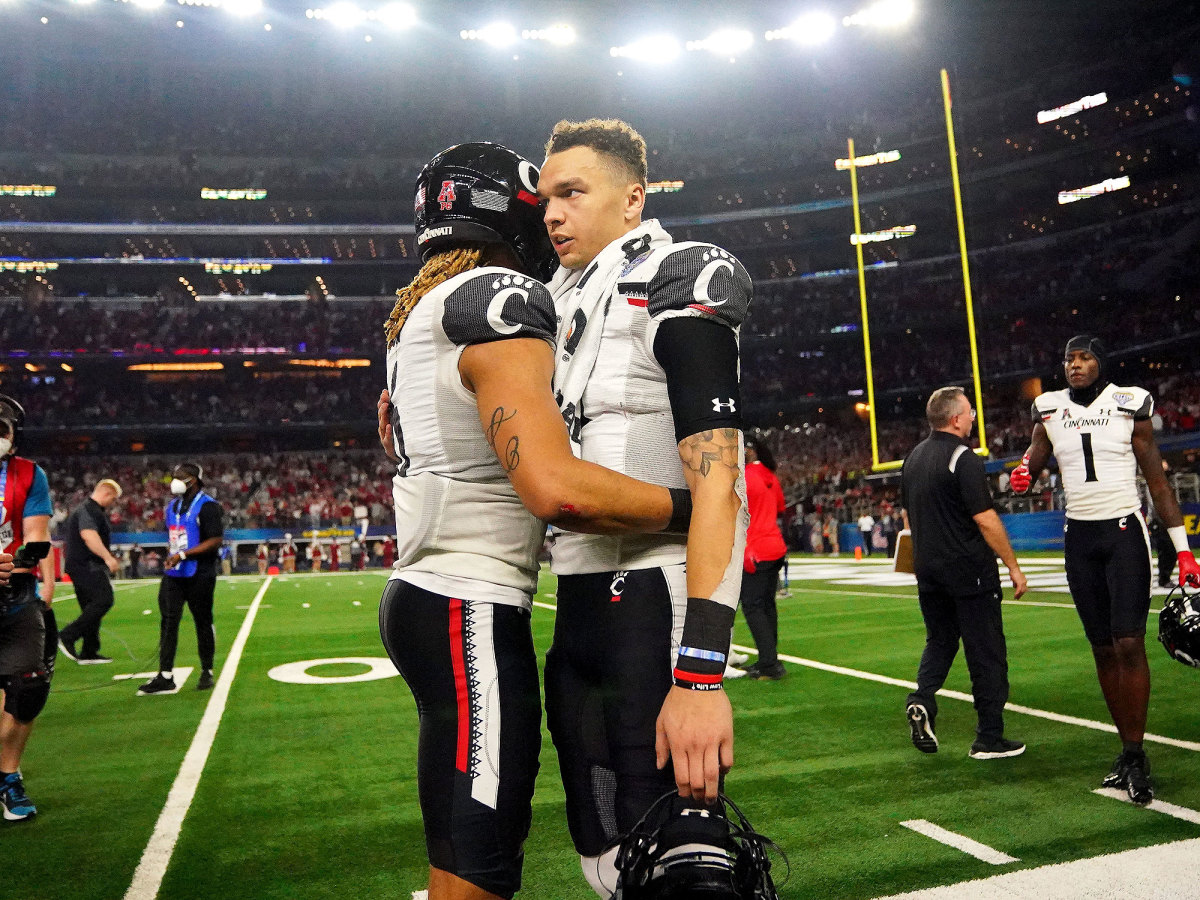 Desmond Ridder (9) and Cincinnati Bearcats safety Bryan Cook (6) embrace.