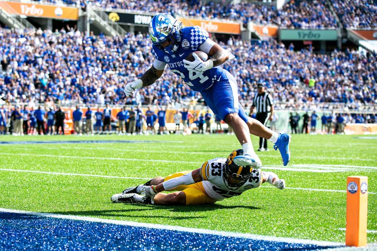 Kentucky running back Chris Rodriguez, Jr. (24) rolls off a tackle from Iowa defensive back Riley Moss (33) into the end zone for a touchdown during a NCAA college football game in the Vrbo Citrus Bowl, Saturday, Jan. 1, 2022, at Camping World Stadium in Orlando, Fla. (Joseph Cress/Iowa City Press-Citizen / USA TODAY)