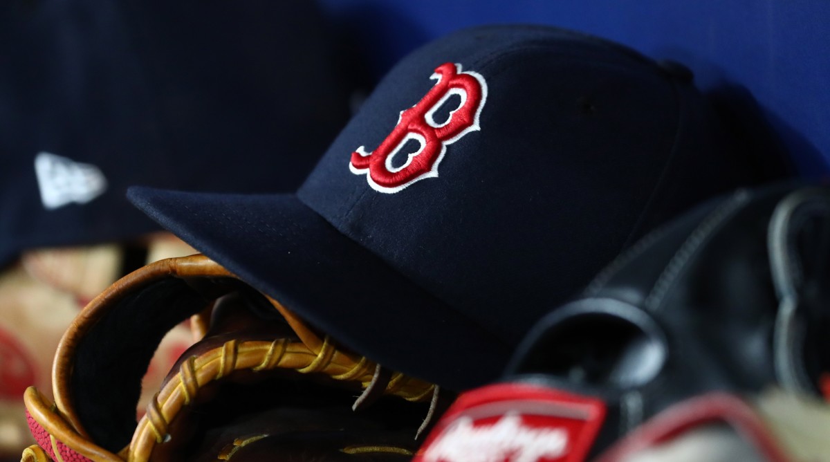 A Red Sox hat on the bench.