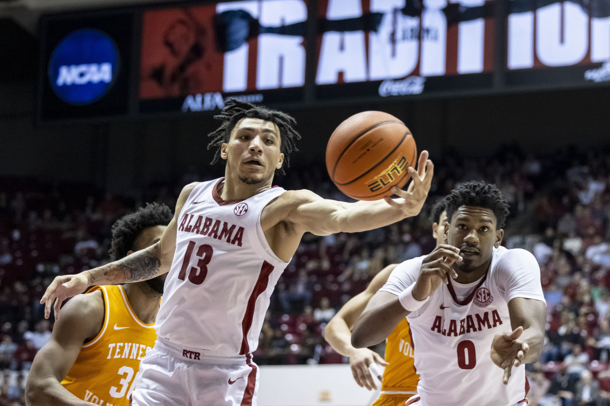 Alabama guard Jahvon Quinerly (13) reaches for a rebound against Tennessee during the first half of an NCAA college basketball game, Wednesday, Dec. 29, 2021, in Tuscaloosa, Ala. At right is Alabama forward Noah Gurley.