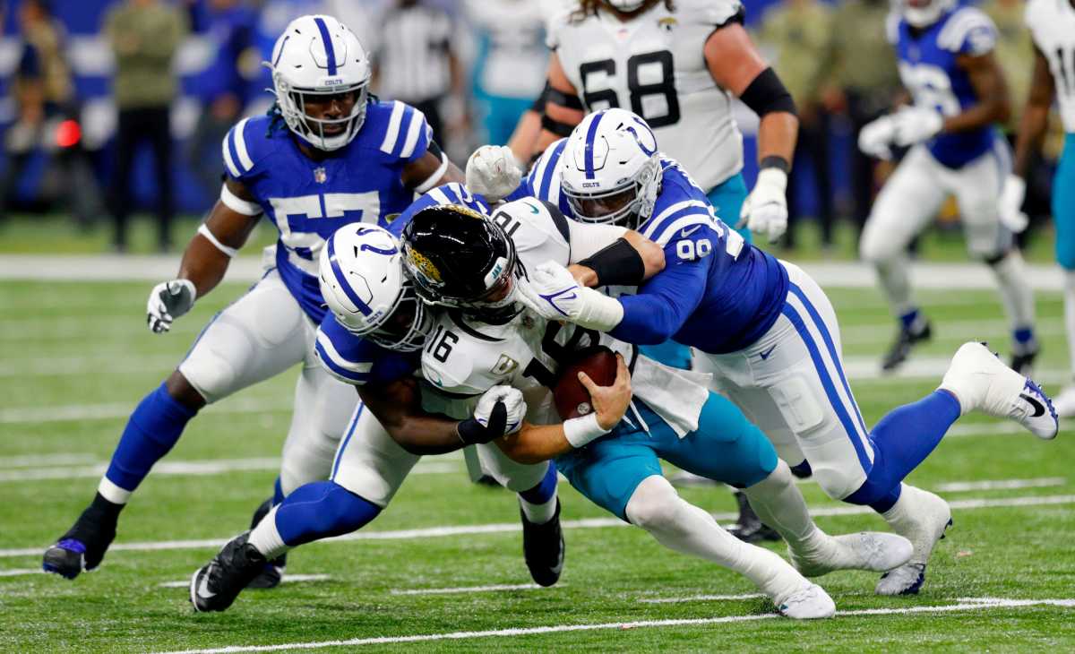 Indianapolis Colts defensive end Kwity Paye (51) and Indianapolis Colts defensive tackle DeForest Buckner (99) bring down Indianapolis Colts wide receiver Ashton Dulin (16) on Sunday, Nov. 14, 2021, during a game against the Jacksonville Jaguars at Lucas Oil Stadium in Indianapolis.
