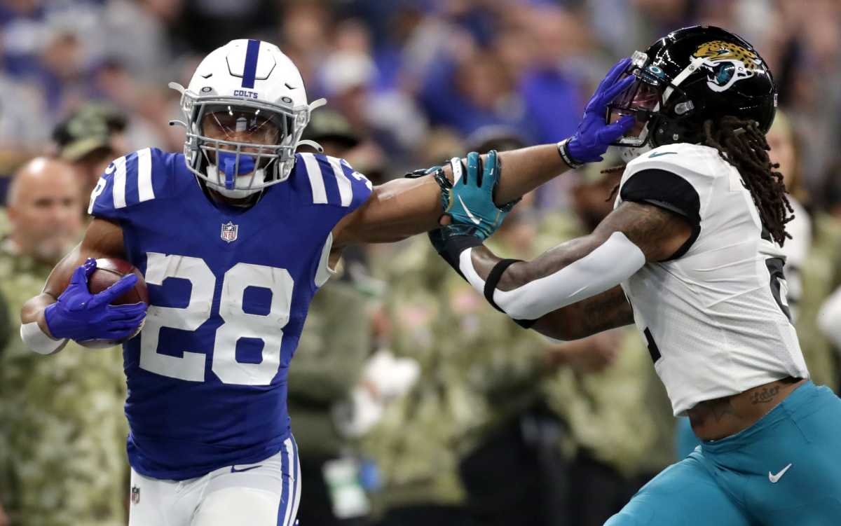 Indianapolis Colts running back Jonathan Taylor (28) still arms Jacksonville Jaguars free safety Rayshawn Jenkins (2) while rushing the ball Sunday, Nov. 14, 2021, during a game against the Jacksonville Jaguars at Lucas Oil Stadium in Indianapolis.