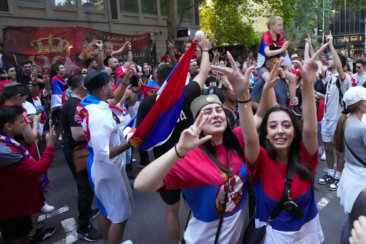 Serbian fans in Melbourne celebrate Monday's court ruling outside an immigration detention hotel where Novak Djokovic has been confined since being denied entry into Australia last week.