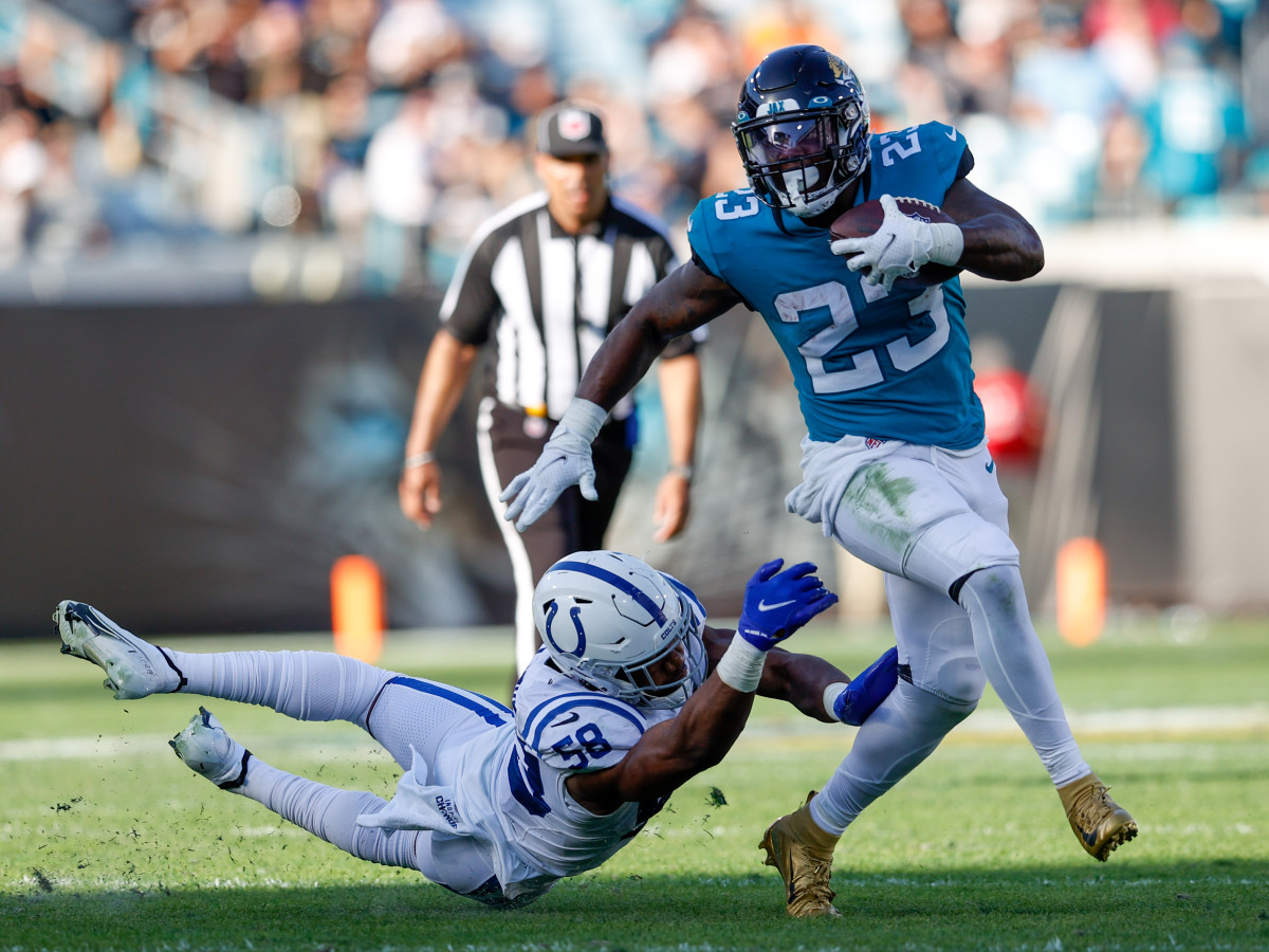 Jan 9, 2022; Jacksonville, Florida, USA; Jacksonville Jaguars running back Ryquell Armstead (23) breaks a tackle from Indianapolis Colts middle linebacker Bobby Okereke (58) in the second half at TIAA Bank Field. Mandatory Credit: Nathan Ray Seebeck-USA TODAY Sports