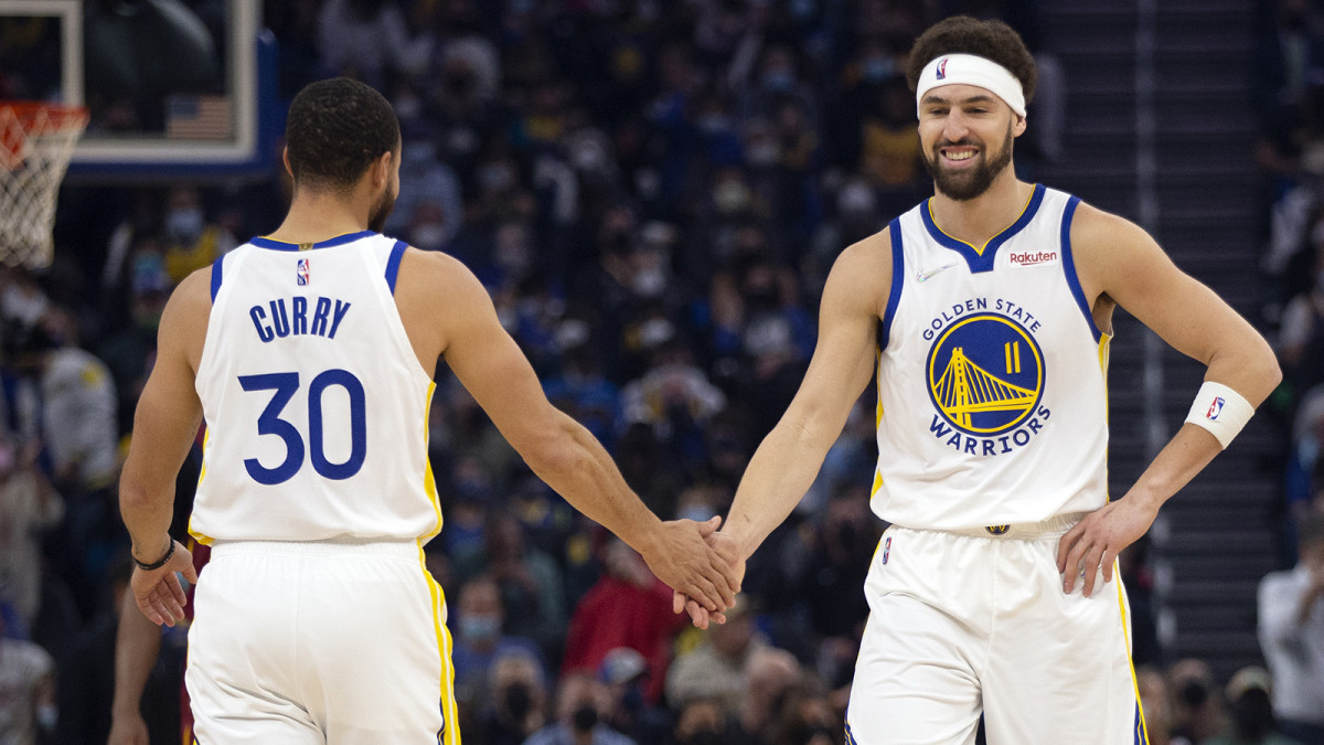 Golden State Warriors guard Klay Thompson (11) gets a congratulatory handshake from teammate Stephen Curry.