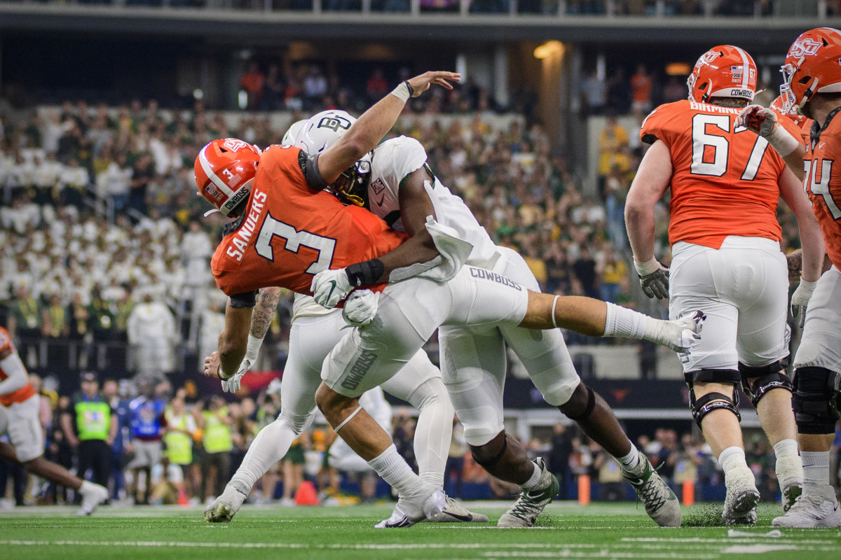 Spencer Sanders takes a hit in Oklahoma State's Big 12 Championship loss at AT&T Stadium.